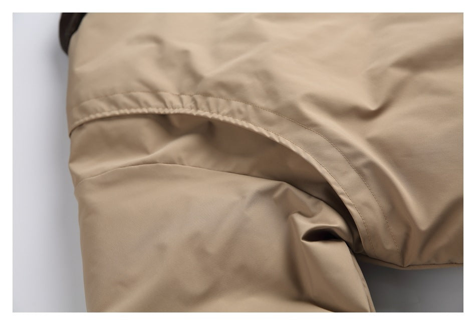 Close-up of tan fabric showing a curved stitched seam and overlapping panel.