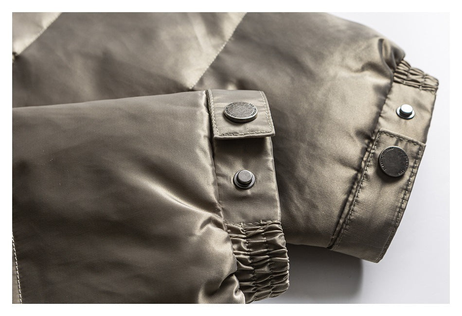Close-up of a taupe jacket cuff with gathered elastic, snap buttons, and a buttoned tab.