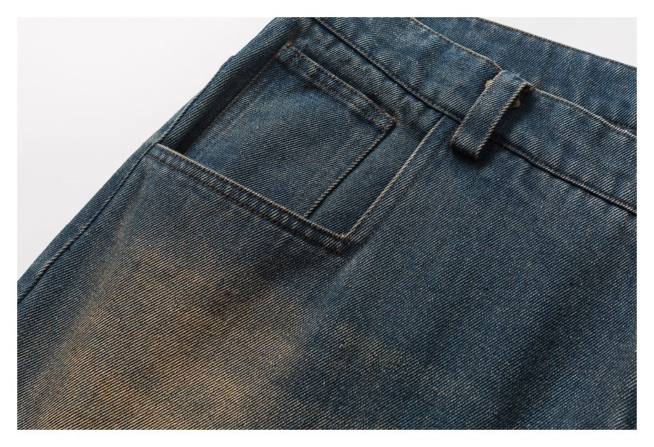 Close-up of a back pocket and belt loop on blue jeans with tan fading and contrast stitching.