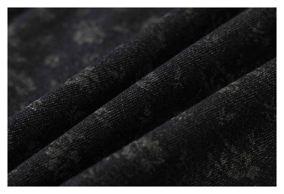 Macro view of dark charcoal fabric with a subtle mottled pattern and visible woven texture.