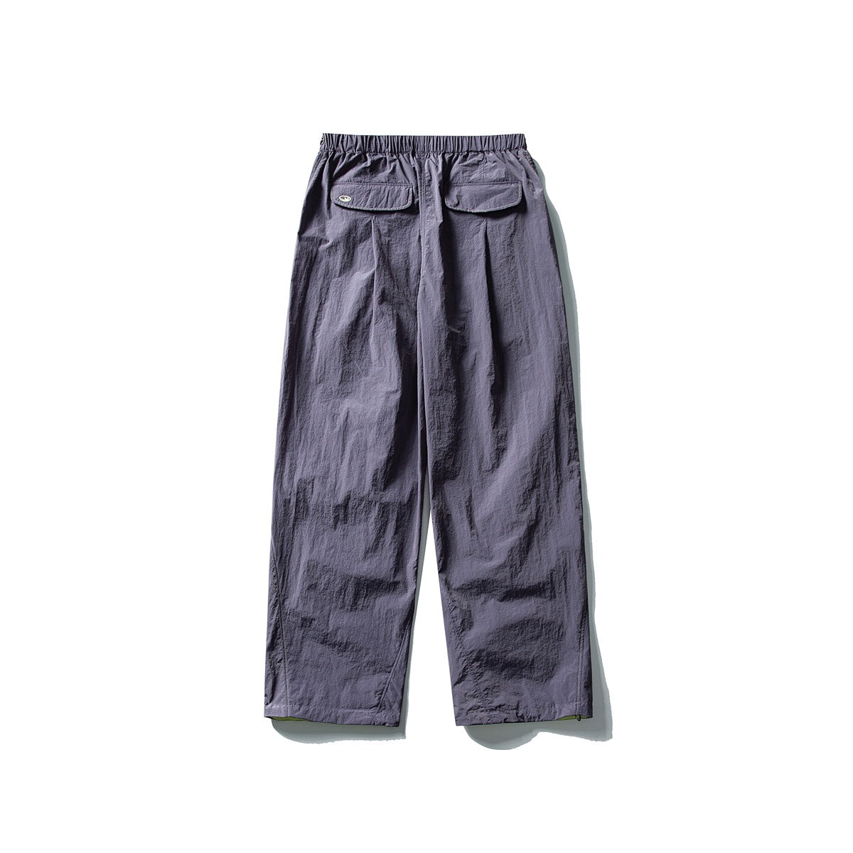 Muted purple wide-leg pants with an elastic waist and two flap back pockets, shown from behind.