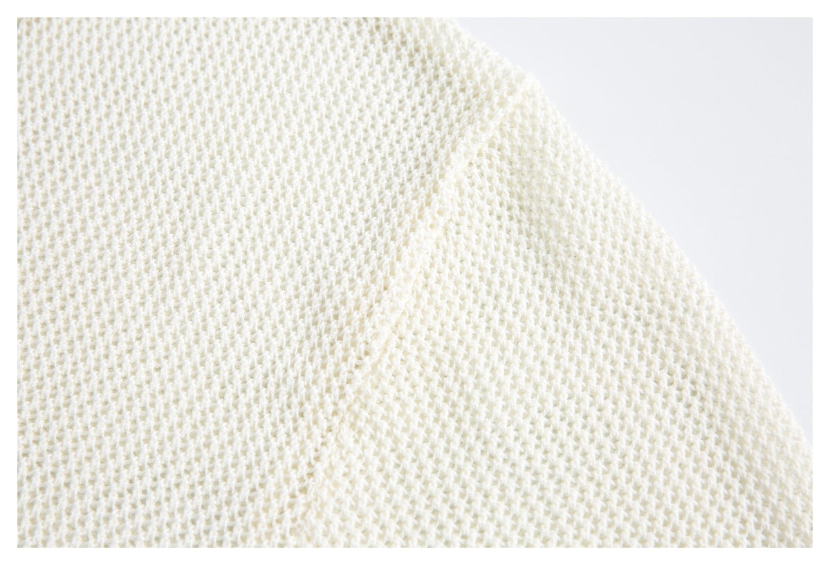 Close-up of the ivory top's open, textured knit fabric.