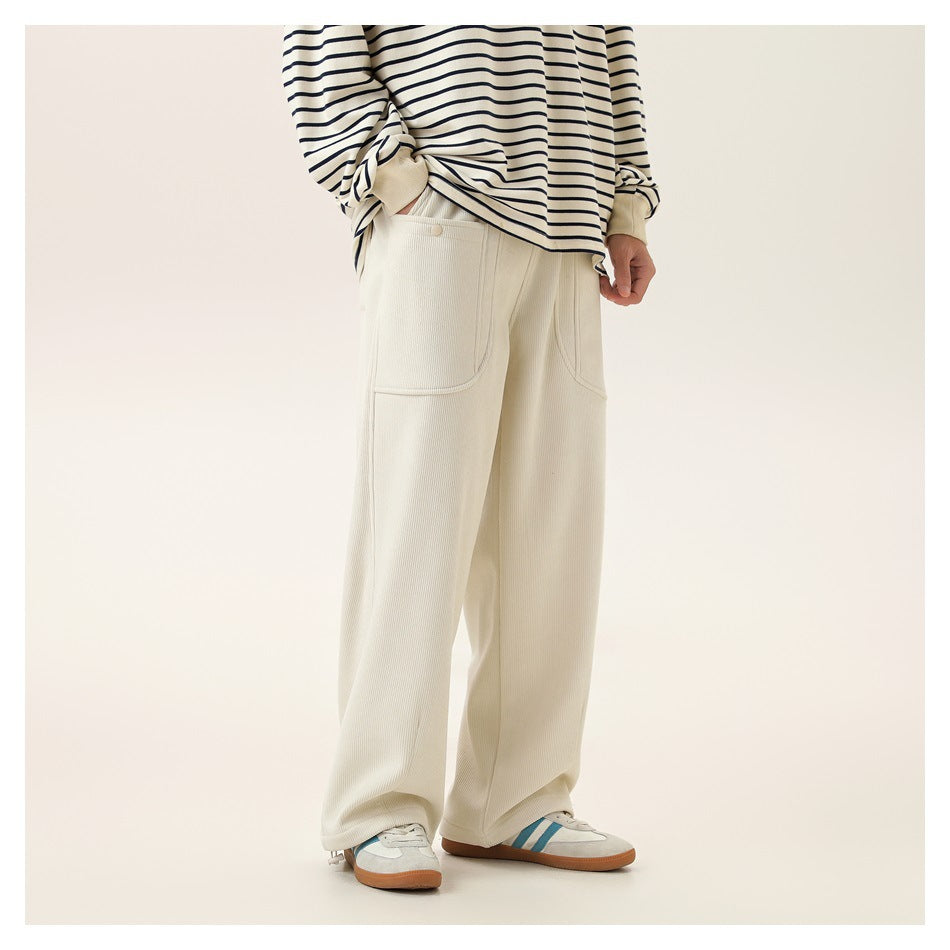 Model in cream ribbed wide-leg pants with front patch pockets, striped top and sneakers, shown from the side