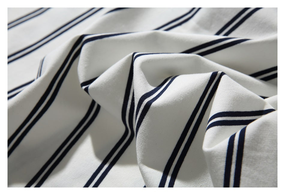 White fabric with navy stripes gathered into folds, shown in close-up.
