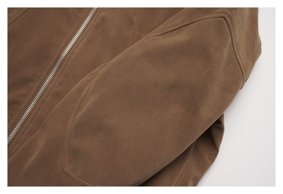 Close-up of a brown jacket showing a silver zipper and large angled pocket.