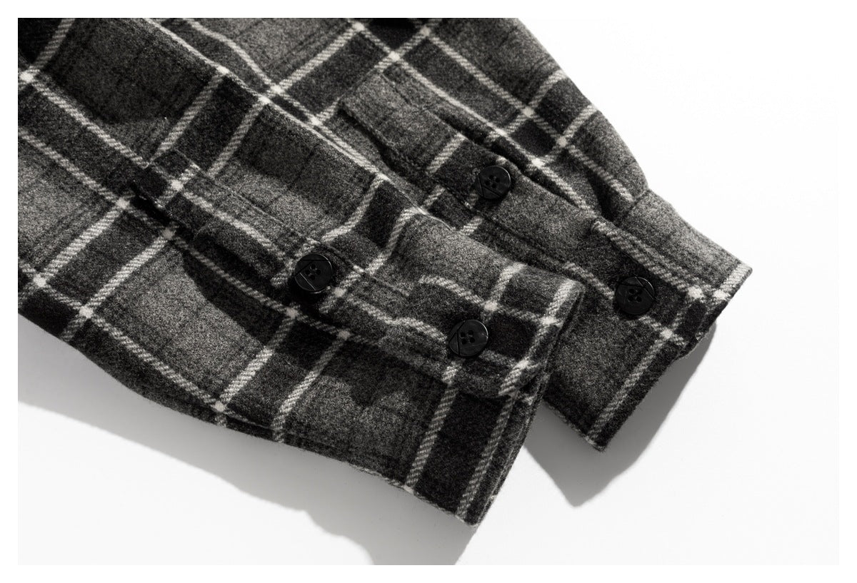Close-up of a dark plaid sleeve cuff with several black buttons.