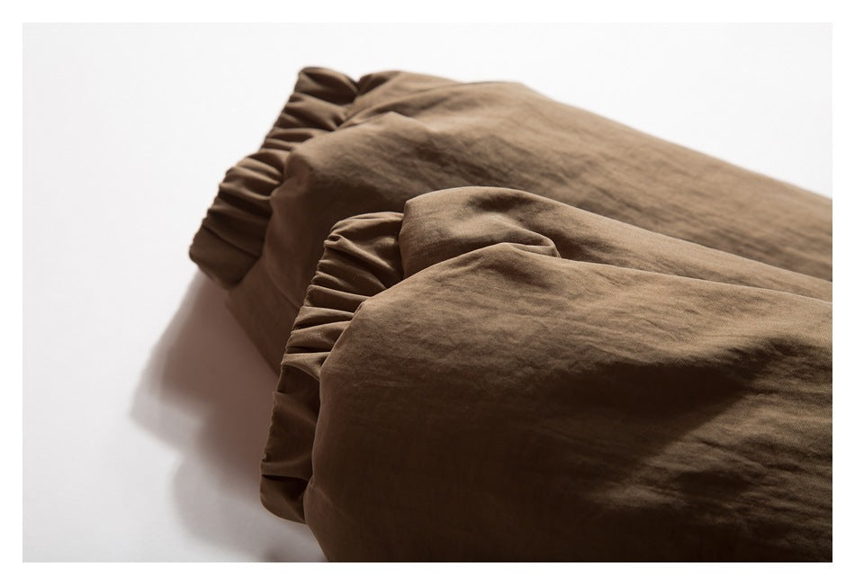 Close-up of brown garment cuffs with gathered, elasticized edges.
