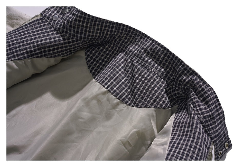 Close-up of the jacket's light lining and dark plaid inner facing with snap fasteners.