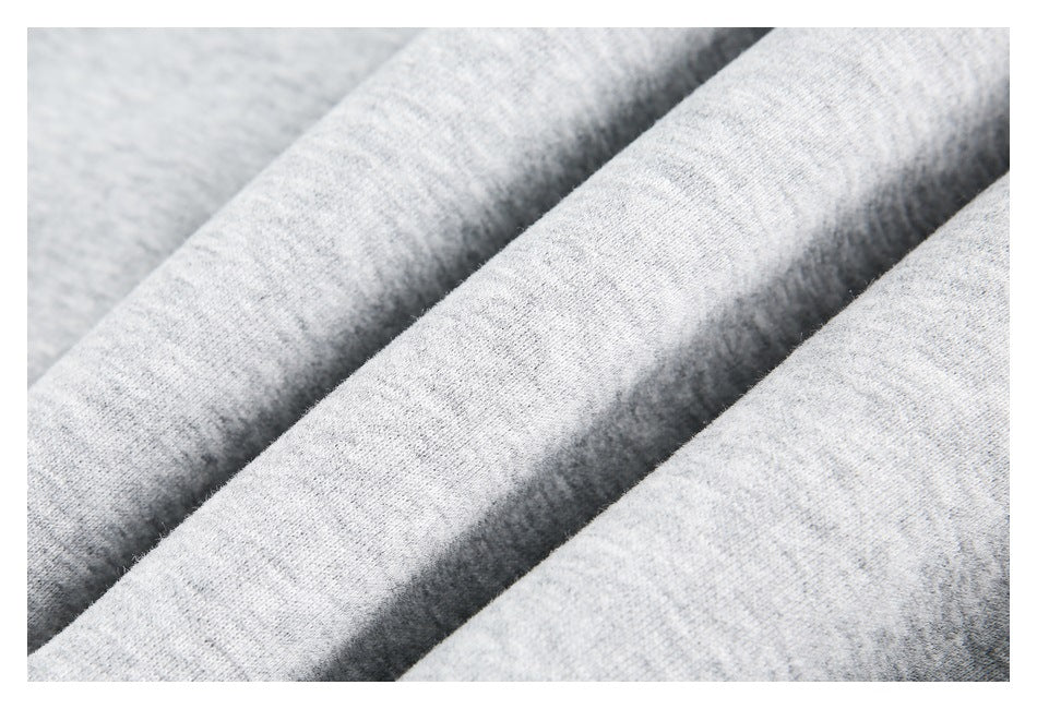 Close-up of light gray knit fabric showing its fine, soft-looking texture and folds.