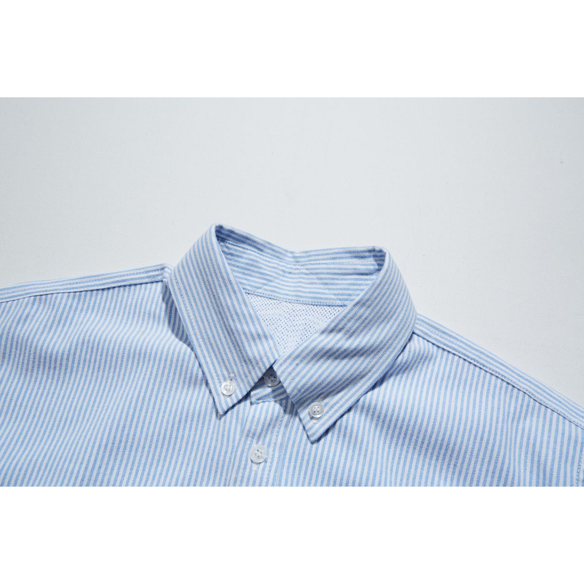 Close-up of a blue-and-white striped shirt collar with button-down points and front button.