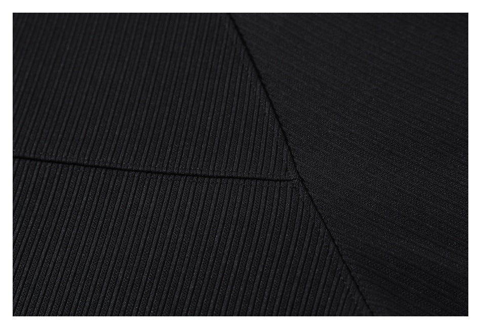 Close-up of black ribbed fabric with a diagonal panel seam.
