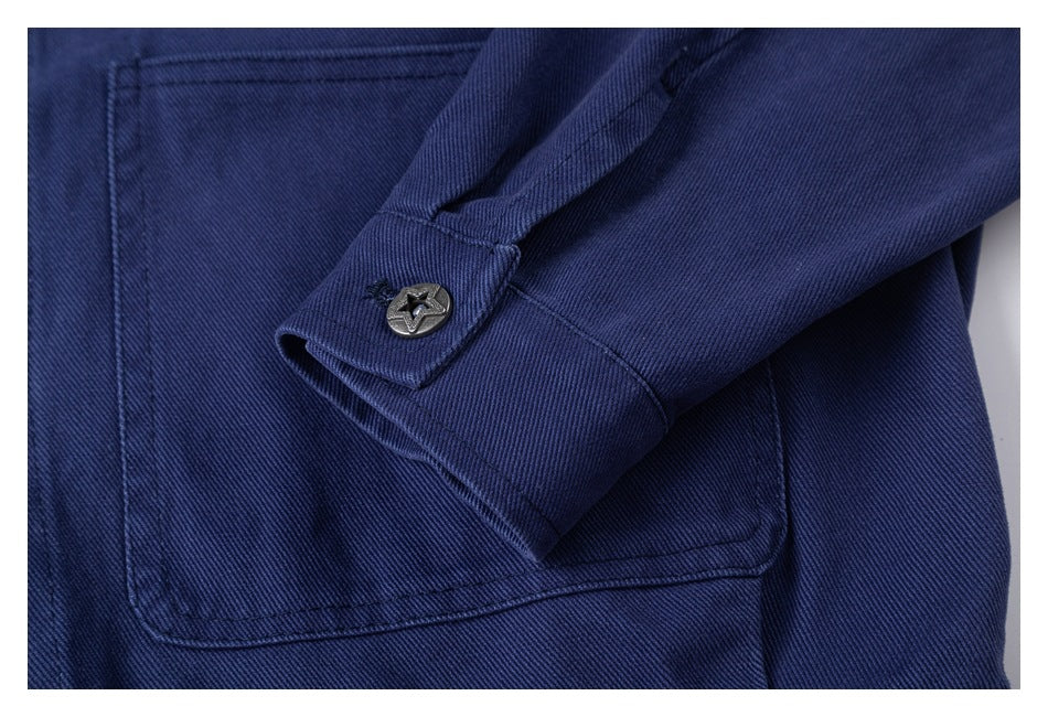 Close-up of the navy jacket sleeve cuff with a star-pattern button, beside a patch pocket.