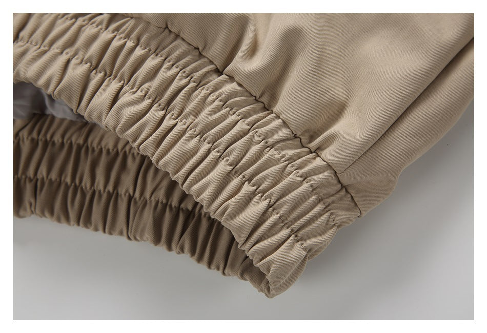 Close-up of the jacket's gathered elastic hem in beige fabric.
