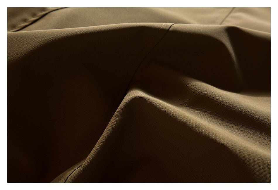 Close-up of brown fabric showing its fine texture, folds, and a curved seam.