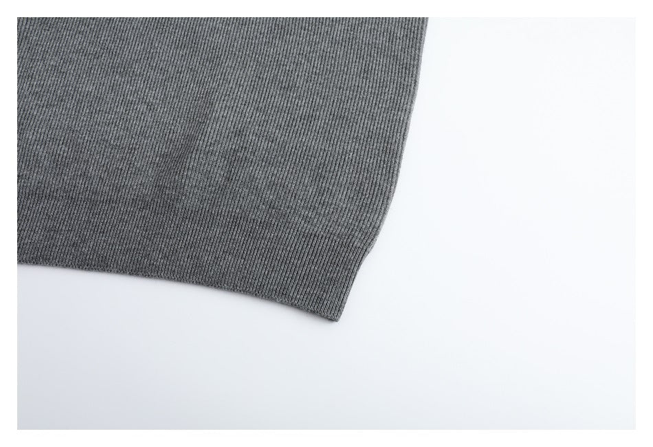 Close-up of the gray cardigan's ribbed lower hem and knit texture.