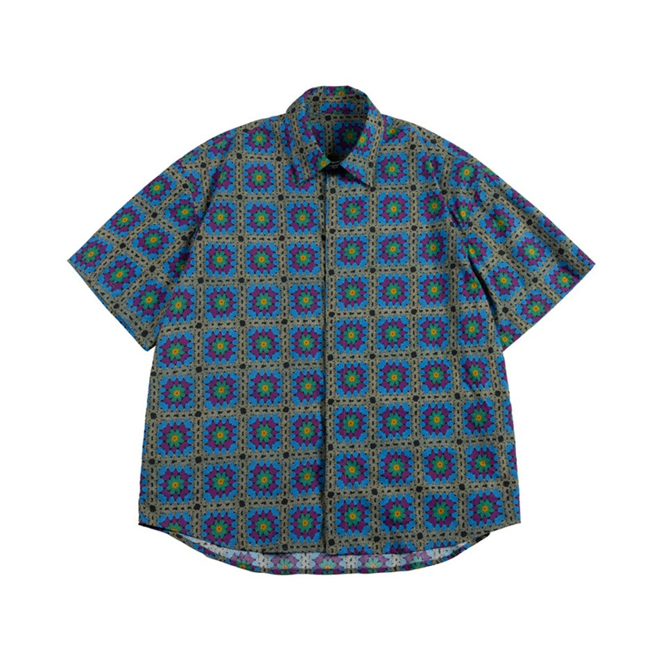 Front view of a gray short-sleeve button-up shirt with a collar and repeating blue, purple, and teal floral squares.
