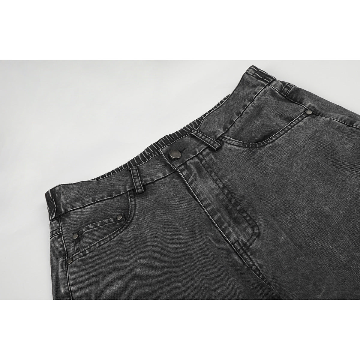 Close-up of charcoal-gray jeans showing the front waistband, button, belt loops, and pockets.