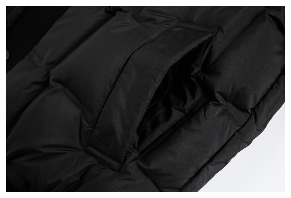 Close-up of a black padded jacket showing a flap pocket and quilted sections.