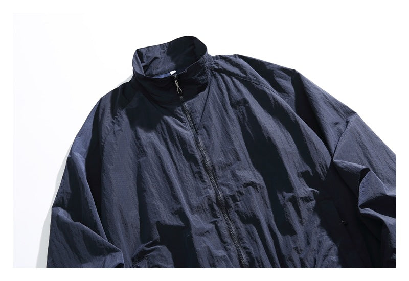 Cropped front view of a dark navy jacket with a stand collar and central zip closure.