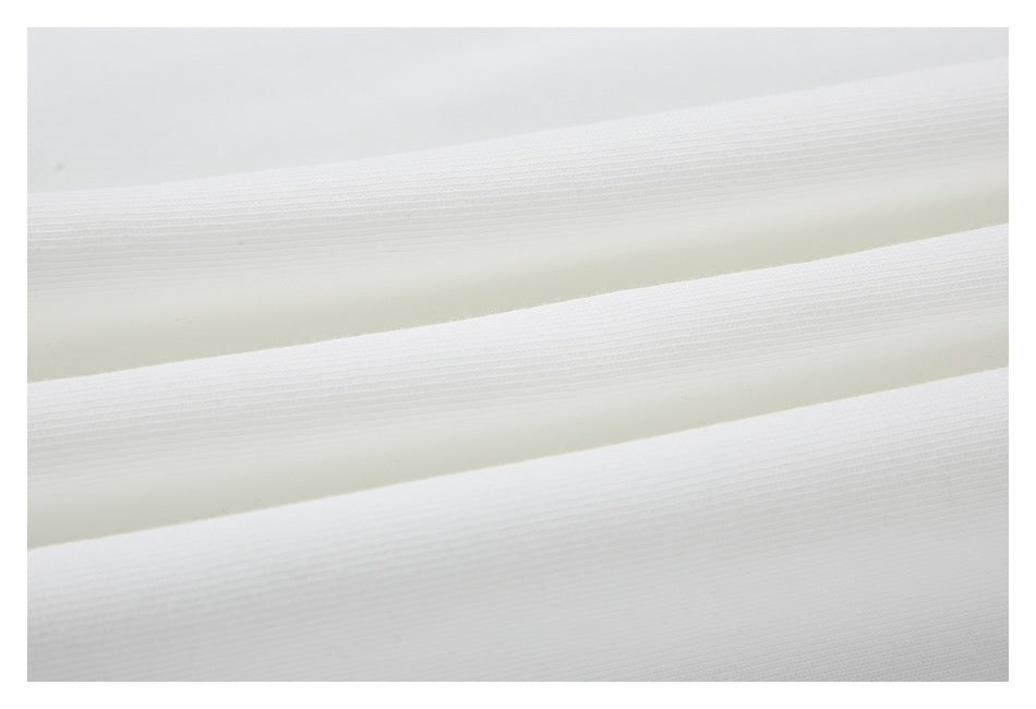 Close-up of white fabric arranged in broad folds, showing its fine ribbed texture.