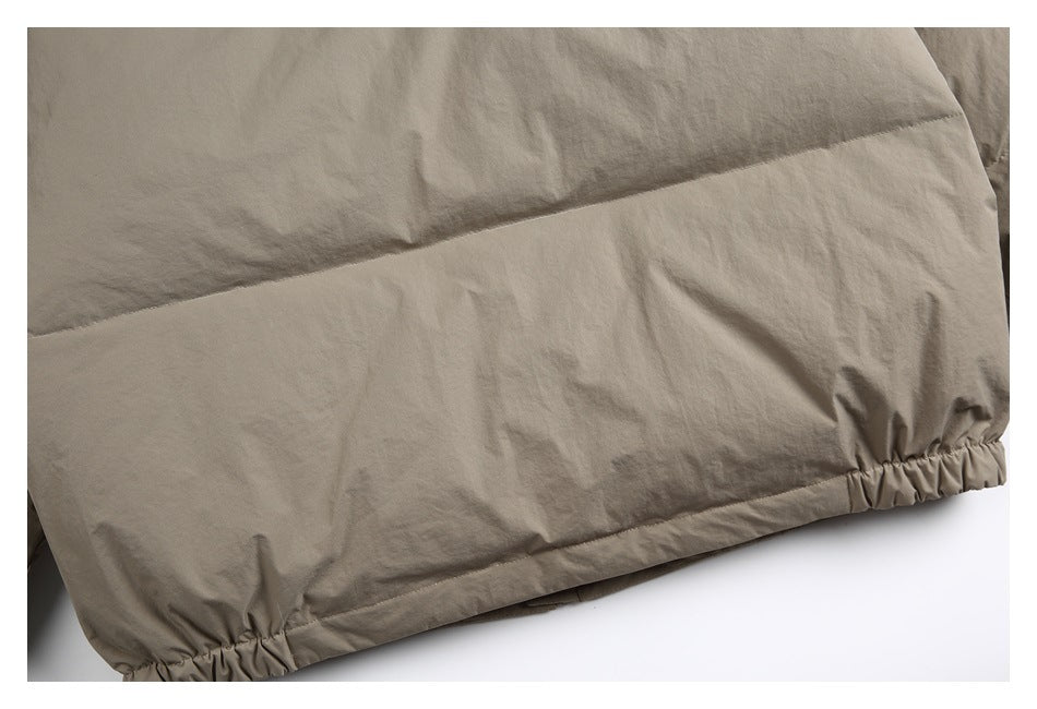 Close-up of the taupe jacket's lower back hem with gathered elastic at the sides.
