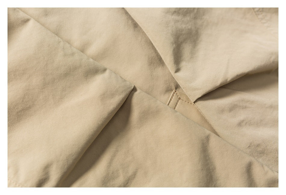 Close-up of beige garment panels meeting at a reinforced stitched seam.
