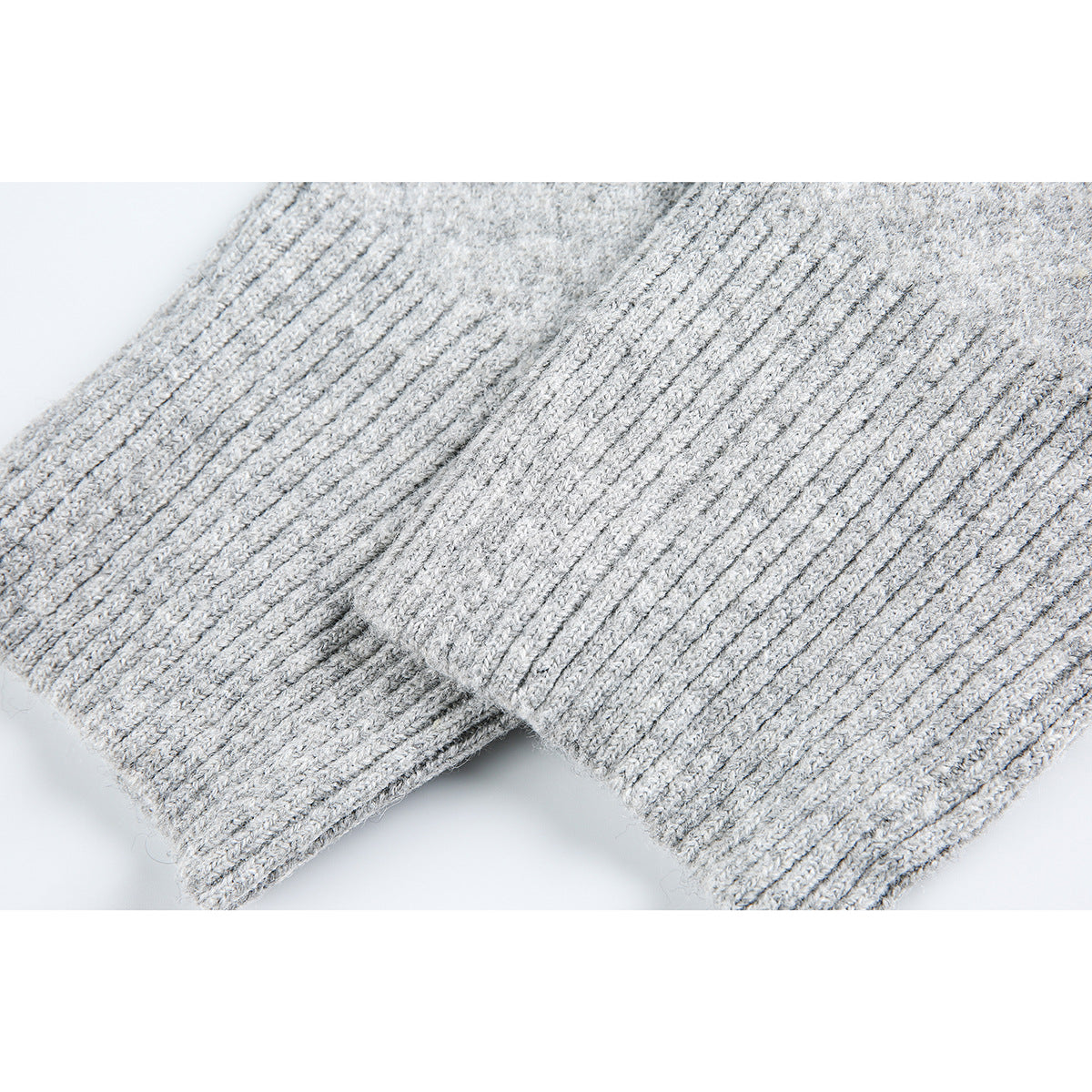 Close-up of the ribbed cuffs and knit texture on a light gray sweater.