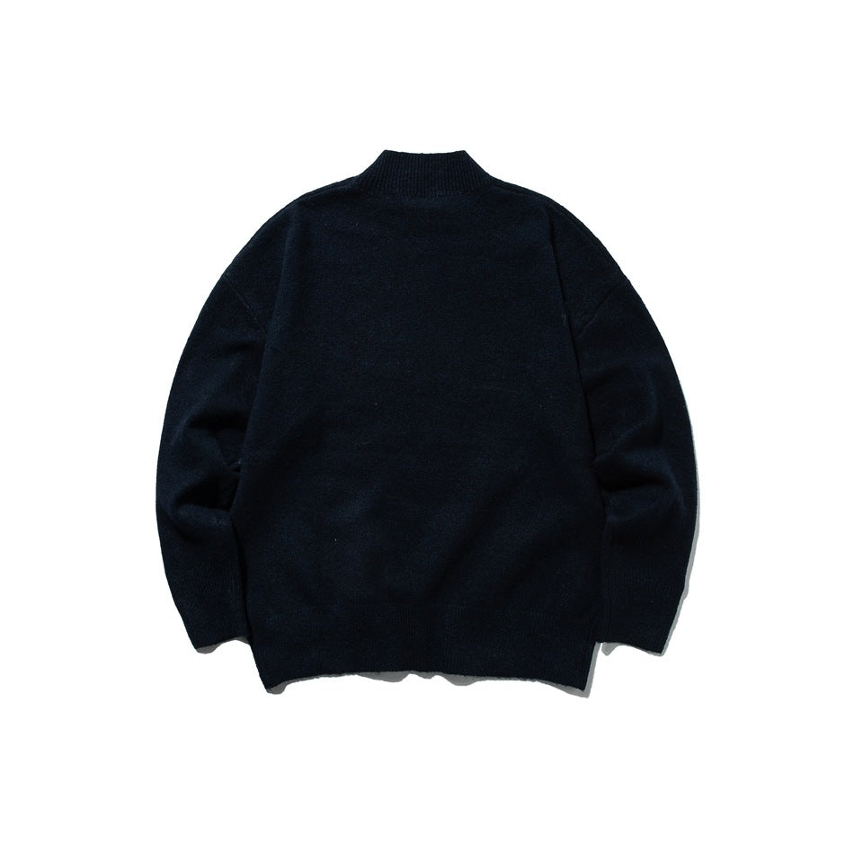 Back view of a dark navy knit sweater with a high ribbed neck, long sleeves, and ribbed hem and cuffs, laid flat.