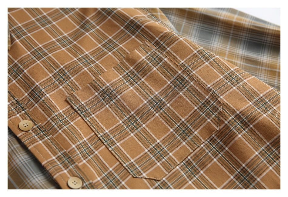 Close-up of the brown plaid shirt's buttoned chest pocket against gray and brown plaid panels.