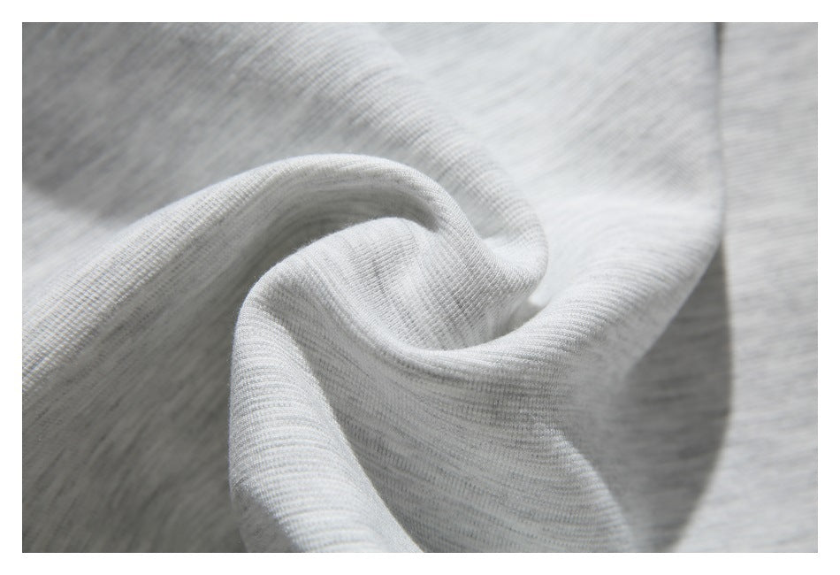 Close-up of the light gray sweatshirt fabric folded to show its heathered knit texture.