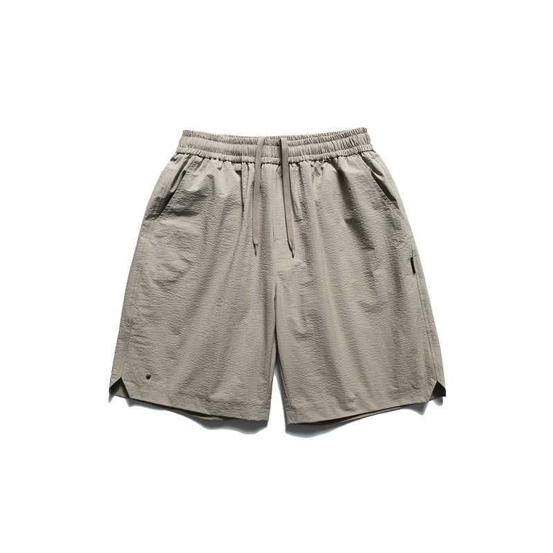 Khaki green textured shorts with drawstring elastic waist, side pockets and notched side hems, flat lay front view