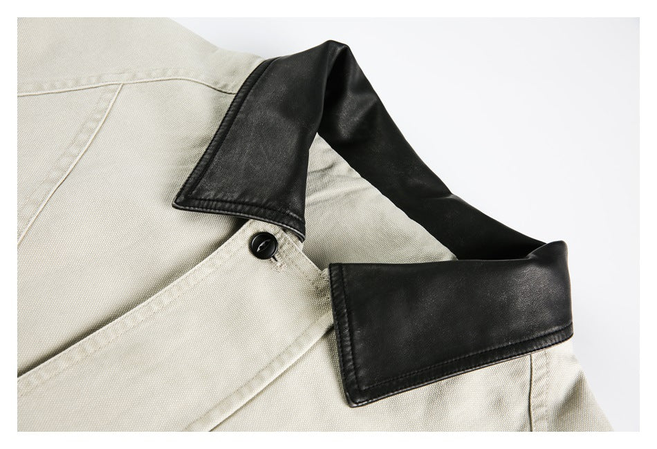Close-up of a cream jacket with a black collar, black button, and stitched front placket.