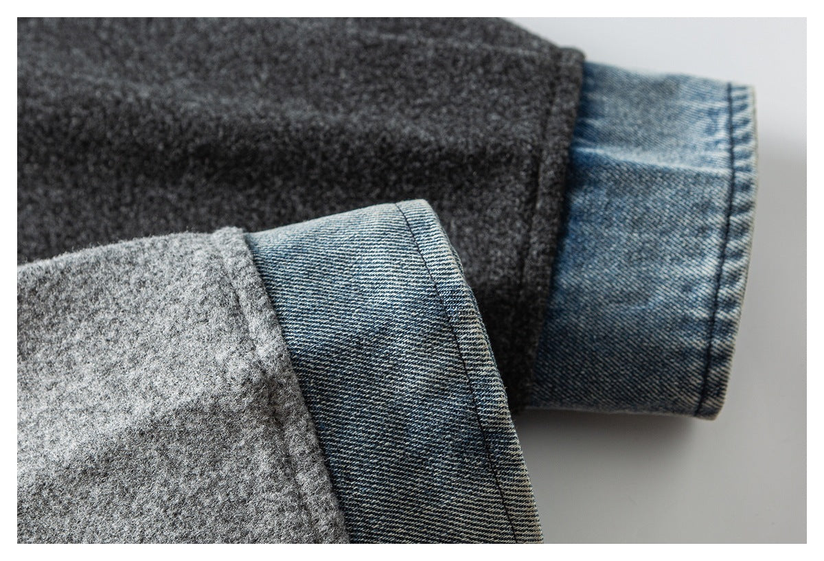 Close-up of a gray coat sleeve cuff with blue denim-like facing folded back.