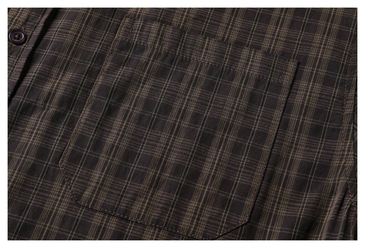 Close-up of a chest pocket on a dark brown plaid button-up shirt.