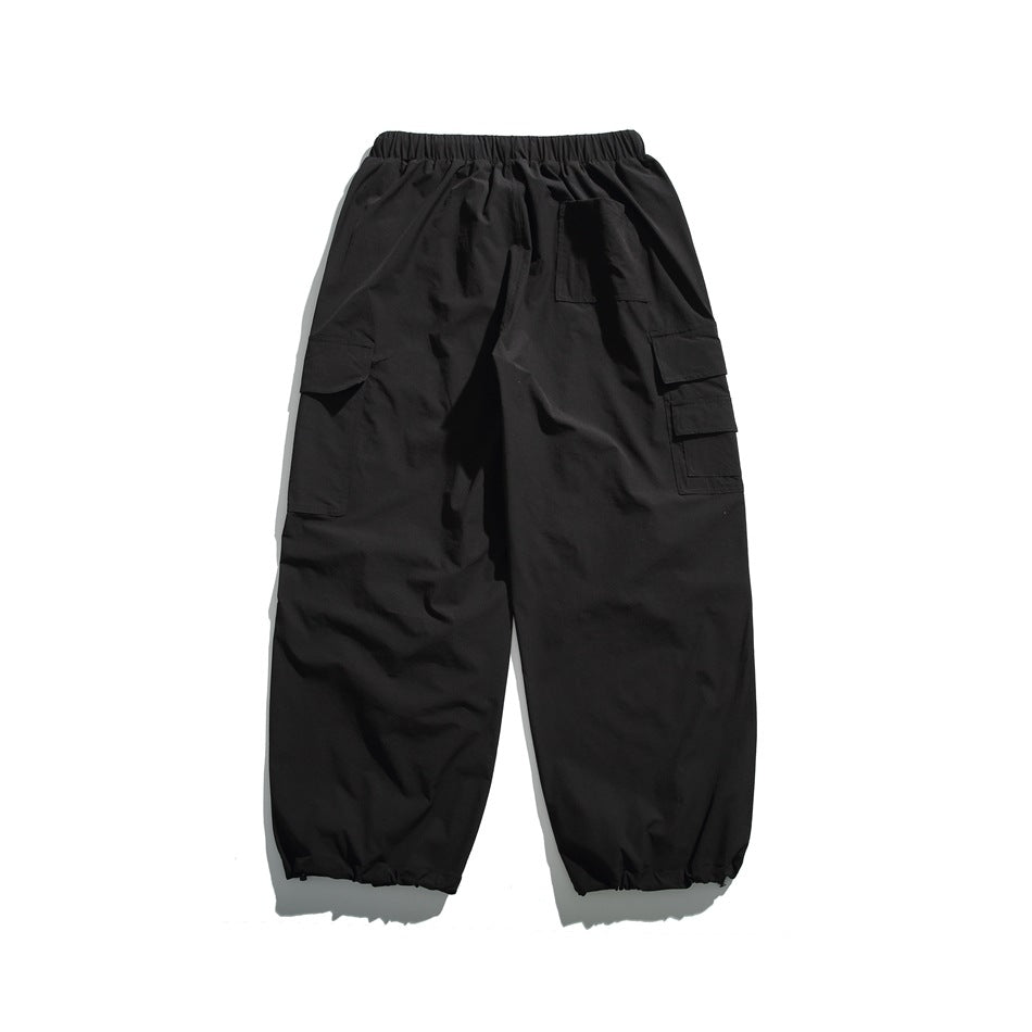 Back view of black cargo joggers with an elastic waist, rear patch pocket, side cargo pockets, and gathered cuffs.