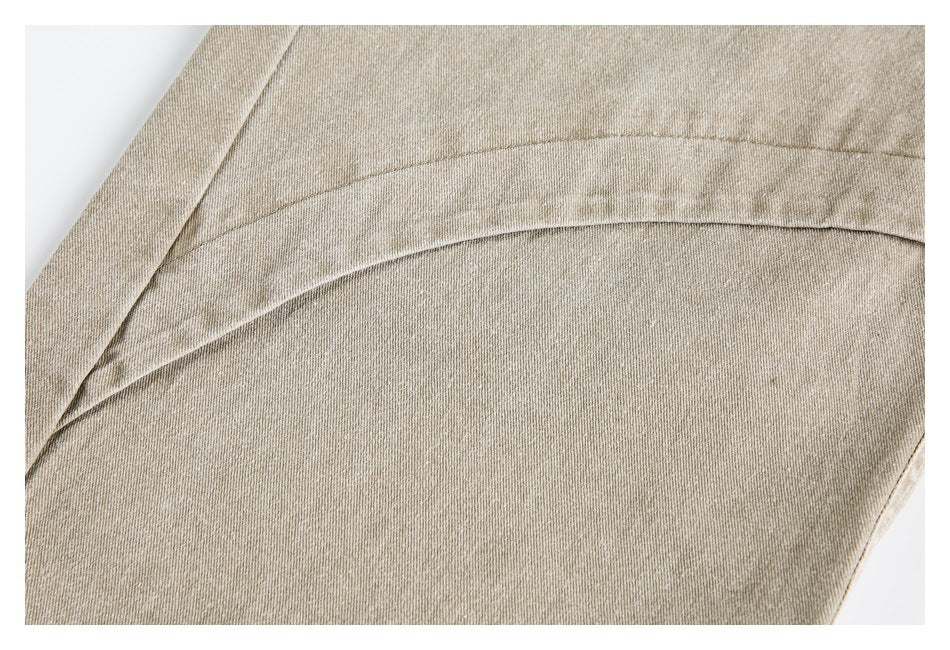 Close-up of beige fabric with curved double stitching and a folded seam.