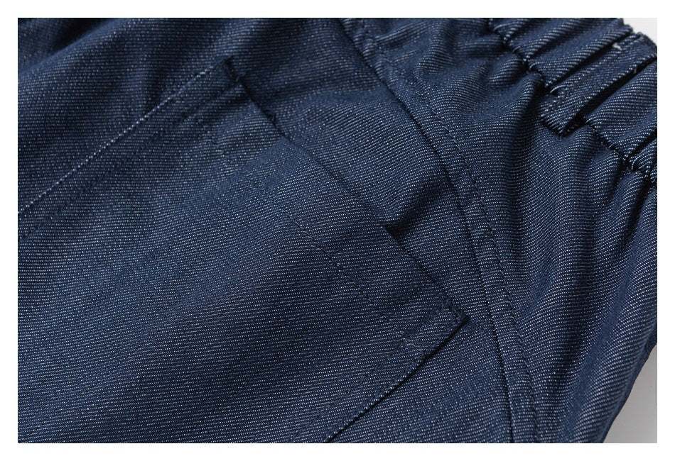 Close-up of a navy trouser pocket, stitching, and gathered waistband.