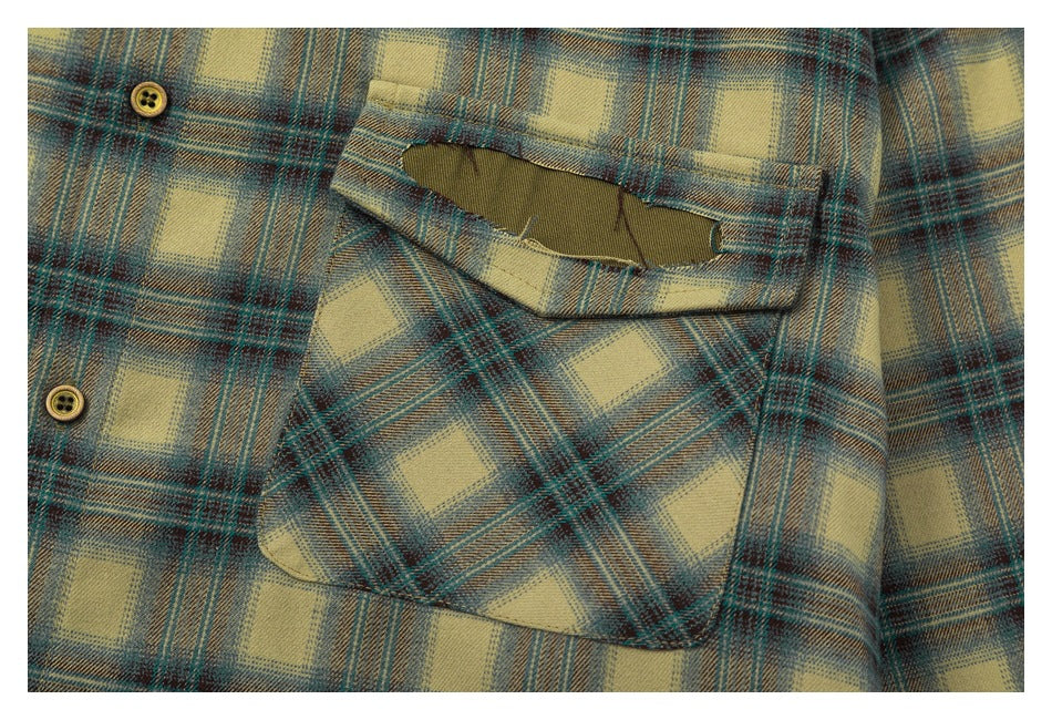 Close-up of the shirt's plaid flap chest pocket with an olive-colored opening detail and nearby buttons.