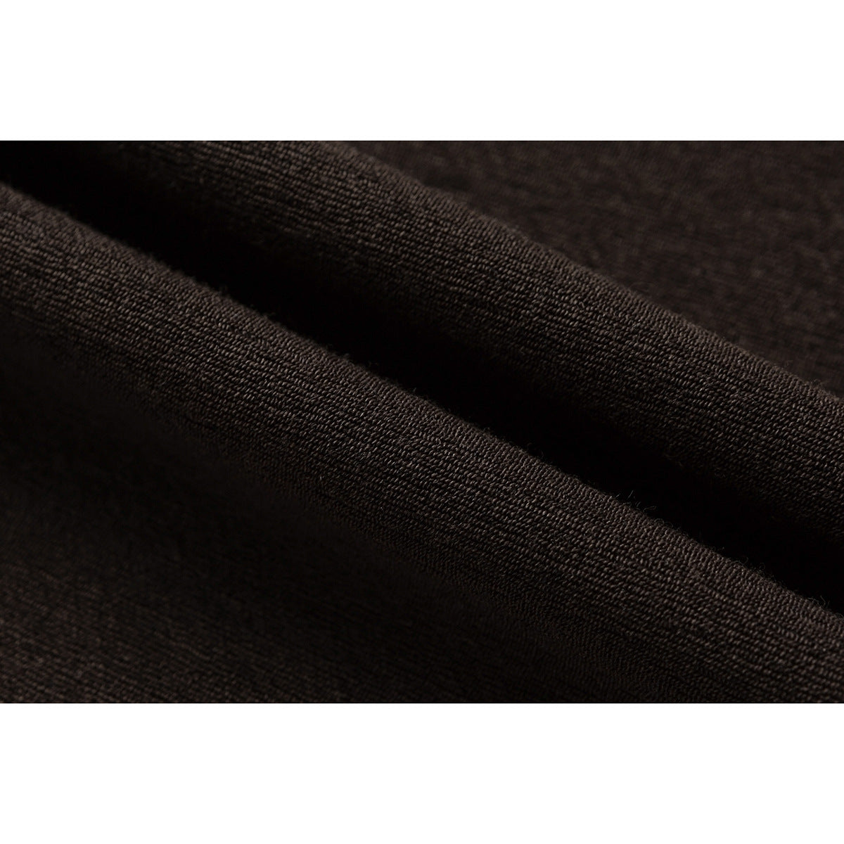 Macro view of dark brown fabric draped in a fold, showing its textured knit.