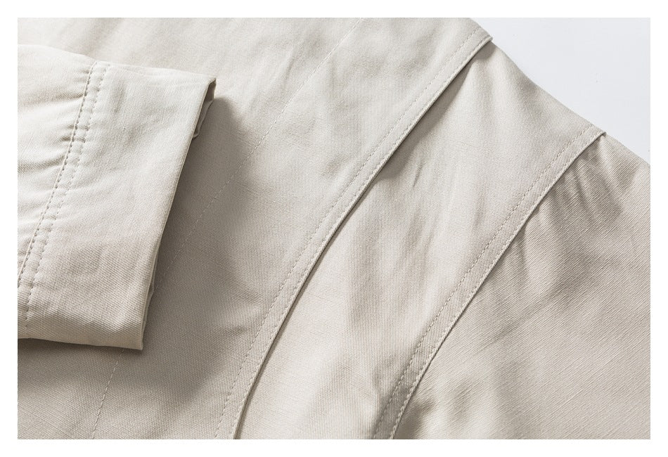 Close-up of a beige garment showing a folded cuff and curved stitched seams.