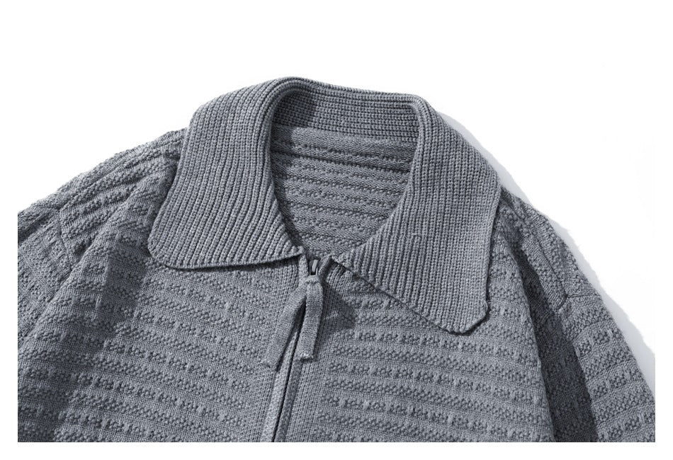 Close-up of a gray cardigan's wide ribbed collar, textured knit, and front zipper.