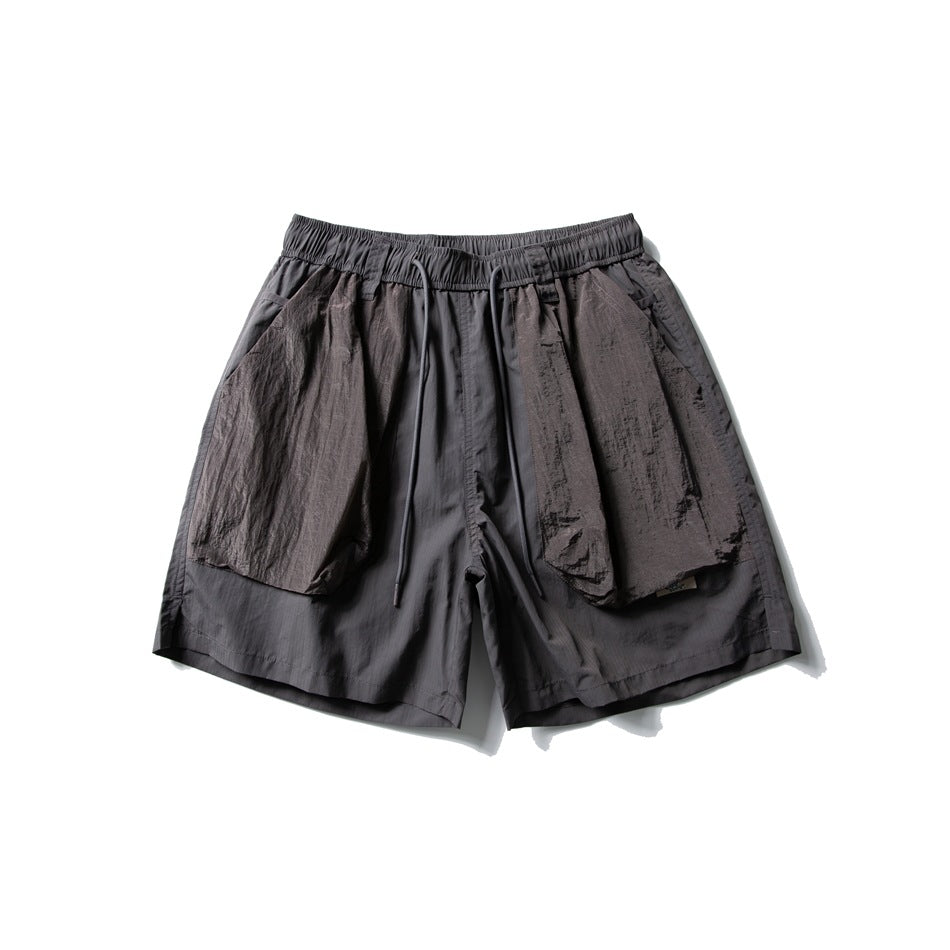 Dark gray drawstring shorts with large brown-gray crinkled patch pockets, flat lay front view