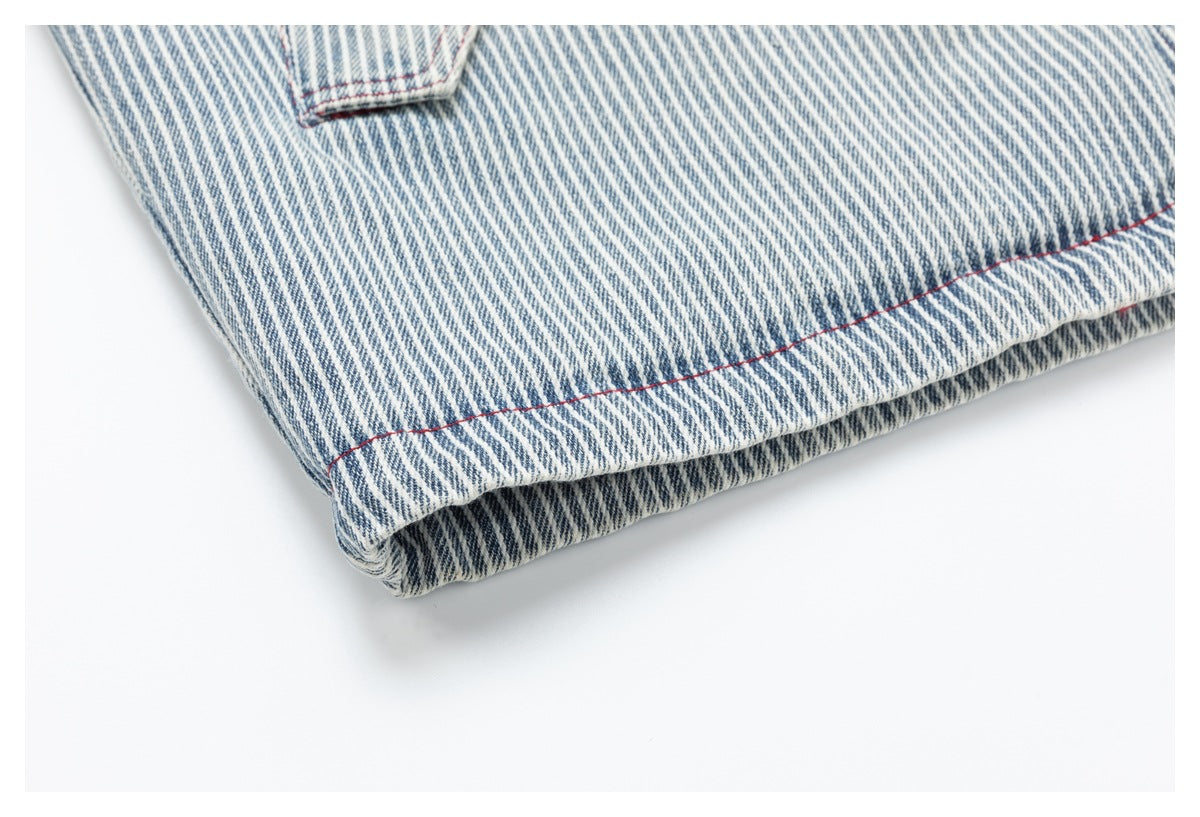 Close-up of the folded hem on a blue-and-white striped garment, finished with red stitching.