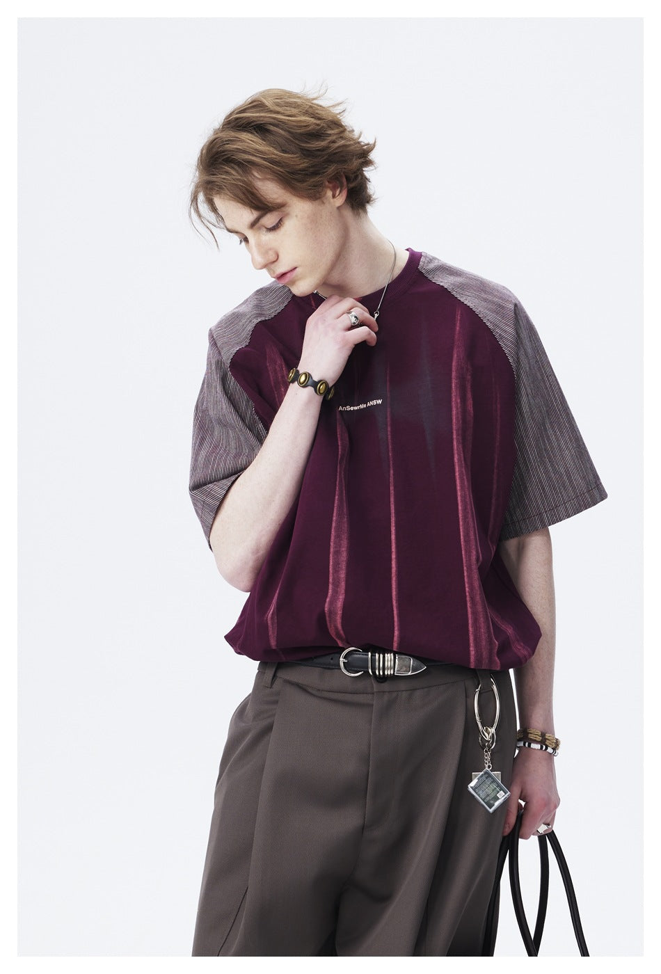 Close view of a model wearing a burgundy short-sleeve shirt with gray striped raglan sleeves and vertical accents.