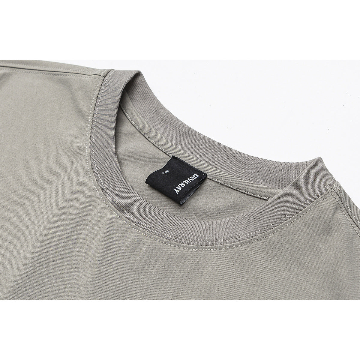 Close-up of a gray crew-neck shirt showing the ribbed collar, stitching, and sewn-in neck label.