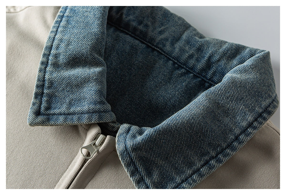 Close-up of a beige jacket with a blue denim collar and matching zipper.