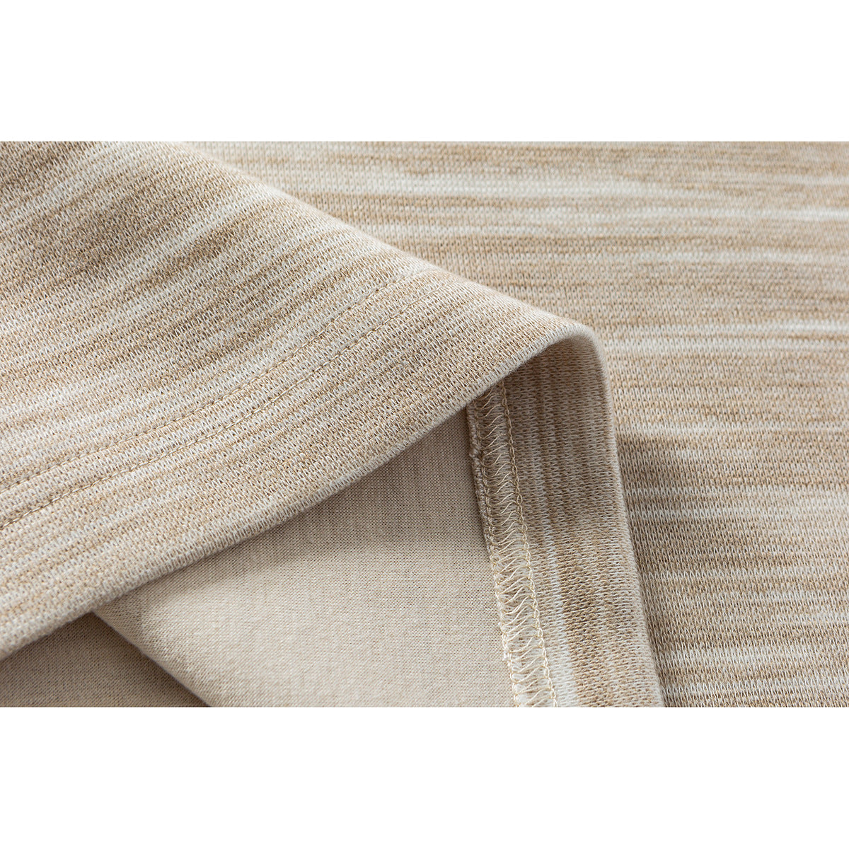 Close-up of a beige heathered shirt's folded hem and overlock stitching.