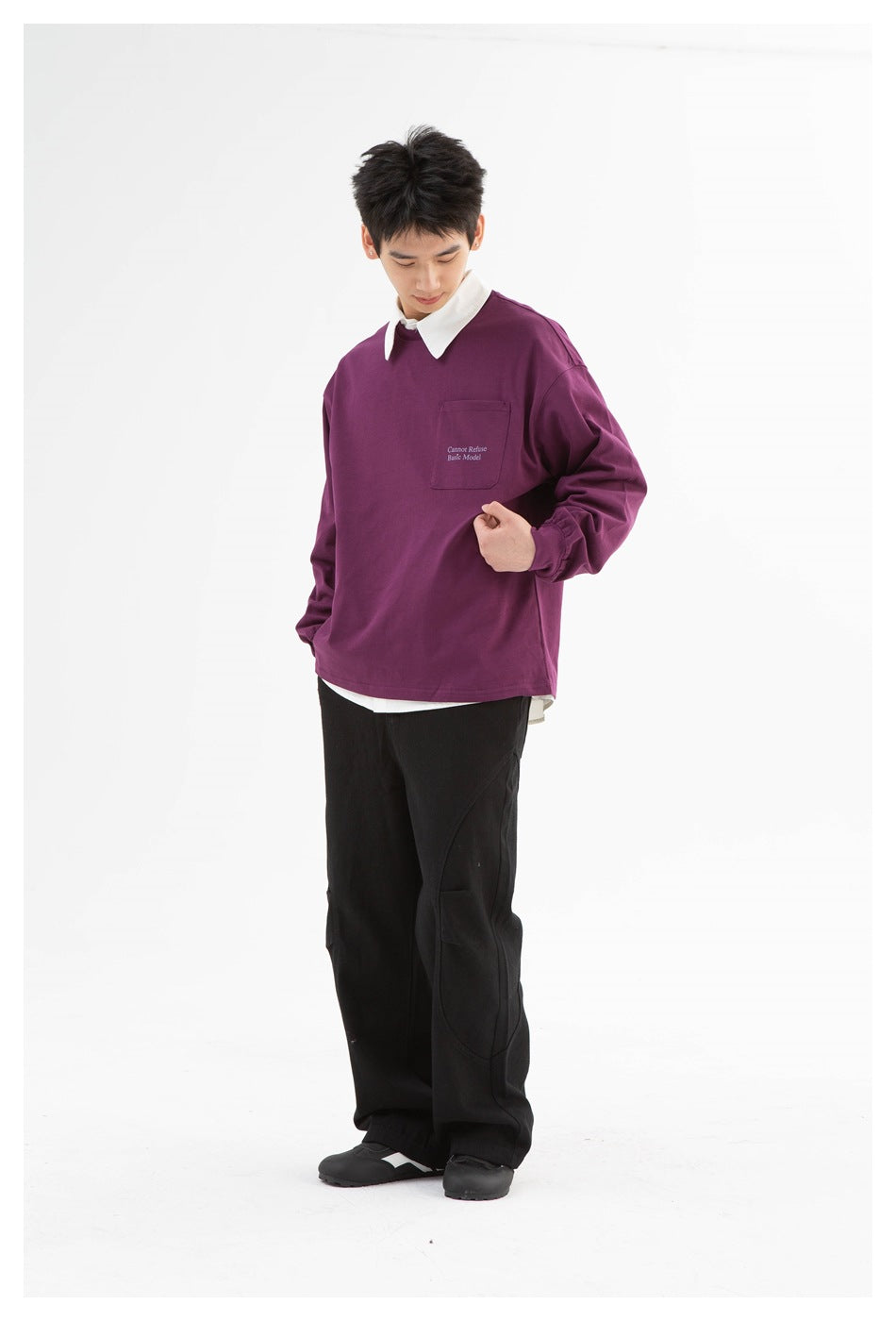 Model wearing plum purple long-sleeve top with chest pocket over a white collared shirt and black pants