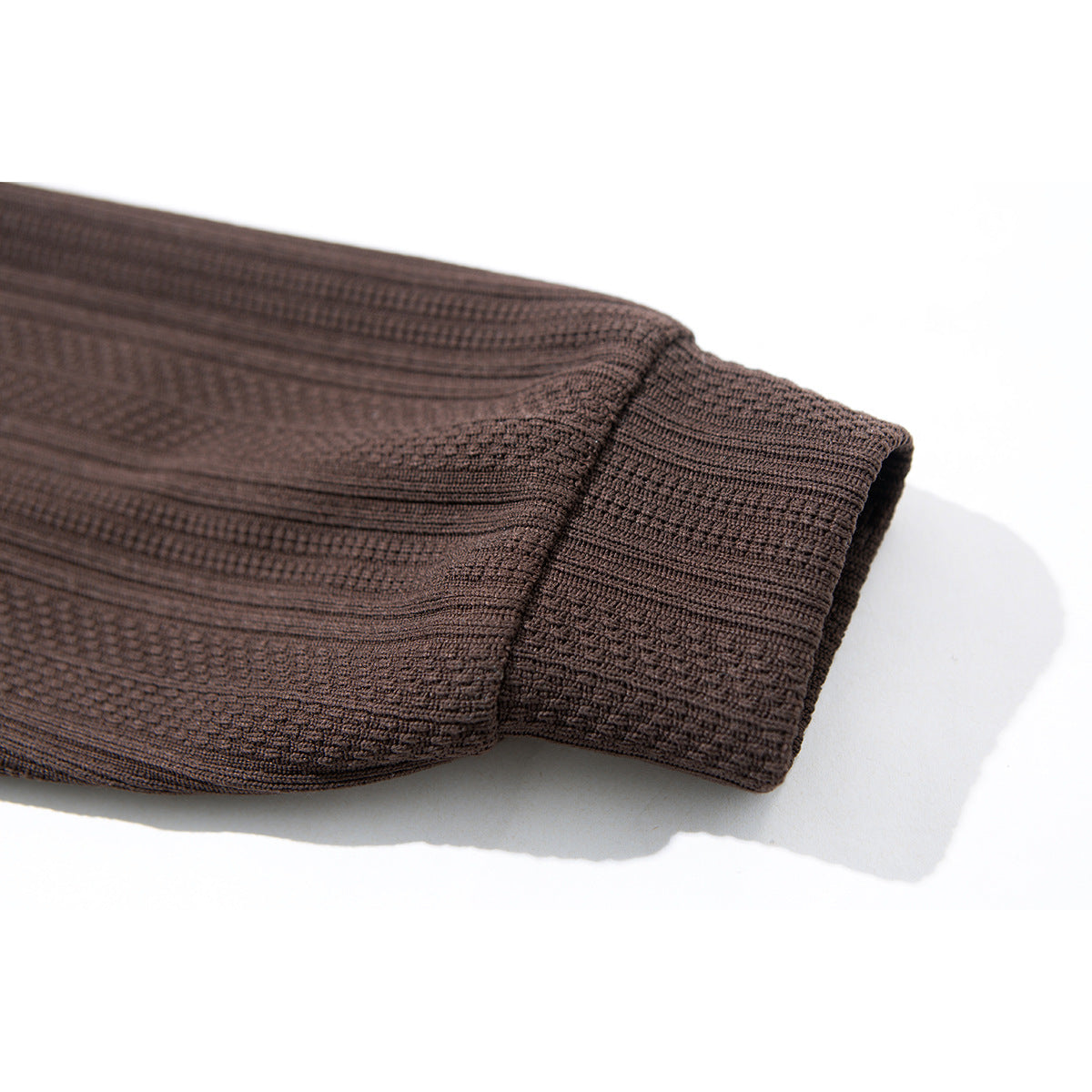 Close-up of the dark brown shirt sleeve and wide cuff, showing the raised textured pattern.