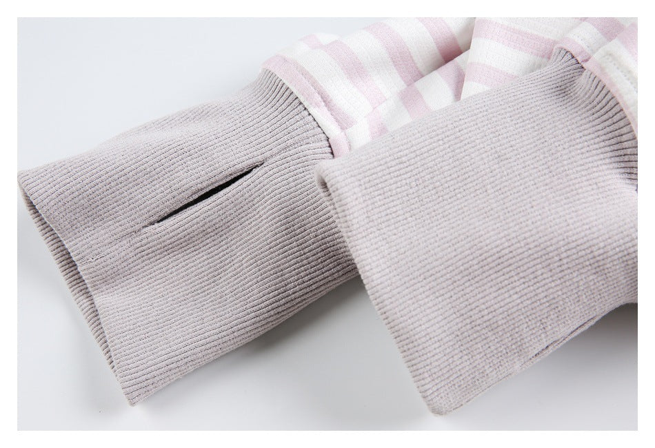 Close-up of wide ribbed light gray cuffs on sleeves of a pale pink and white striped garment.